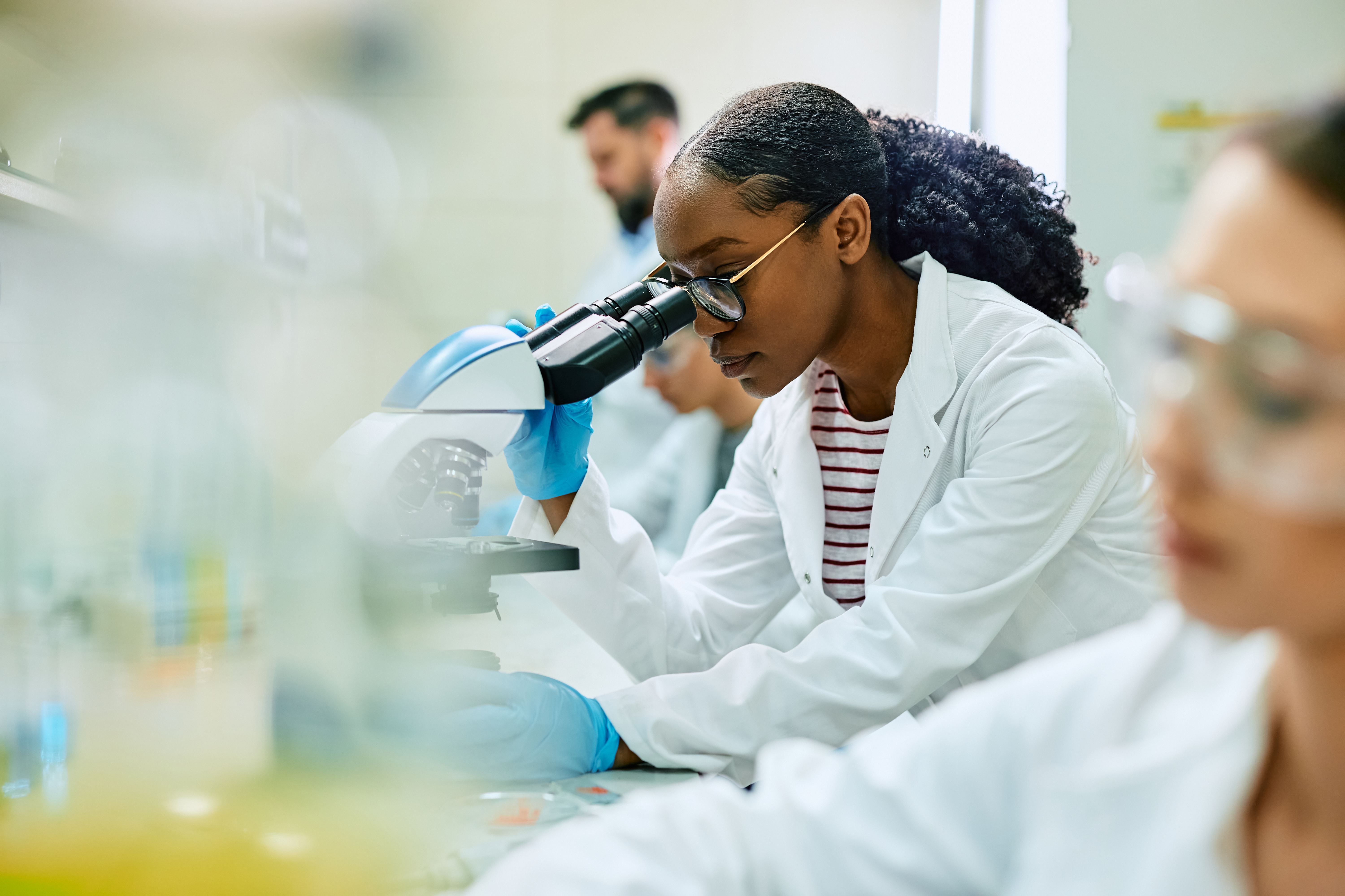 A researcher looking through a microscope